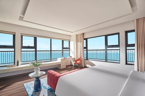 头顿Vias Hotel Vung Tau - Inclusive Transportation的酒店客房设有一张大床和大窗户