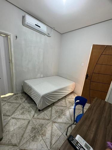 帕劳阿佩巴斯Kitnet mobiliada em Parauapebas的客房设有一张床、一张桌子和一把椅子。