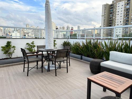圣保罗Apartamento novo decorado com sacada e linda vista da Cidade的阳台的天井配有桌椅