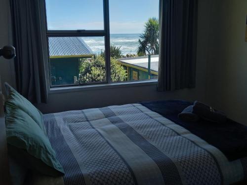 普纳凯基普纳凯基海滩旅舍的一间卧室设有一张床和一个大窗户