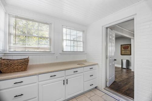 奥古斯塔Forest Hills Cottage的白色的厨房配有白色橱柜和窗户