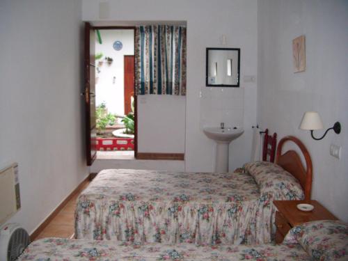 赫雷斯-德拉弗龙特拉圣安德烈斯一号膳食公寓酒店的一间卧室设有两张床、一个水槽和一个窗口