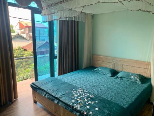 奠边府市Home Hưng Trang的一间卧室设有一张床和一个大窗户