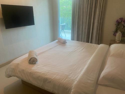 三百岭The Sea Condominium的卧室内的白色床和毛巾