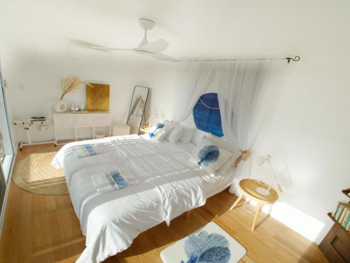 MidgetonDUENDE Sirène Mermaid的卧室配有带蓝色枕头的大型白色床