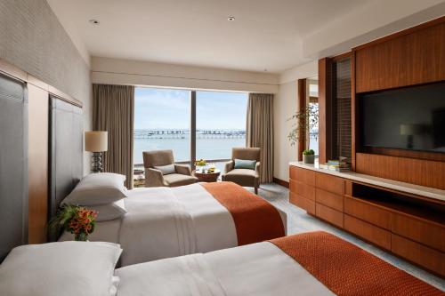 澳门Mandarin Oriental, Macau的酒店客房设有两张床和一台平面电视。