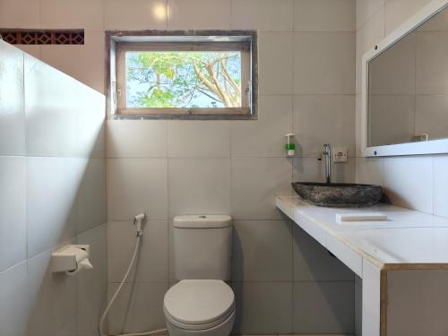 乌鲁瓦图Alam Cottage Uluwatu的一间带卫生间、水槽和窗户的浴室