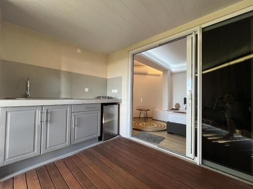 帕皮提Ononui Airport Studio的厨房设有滑动玻璃门,可通往卧室