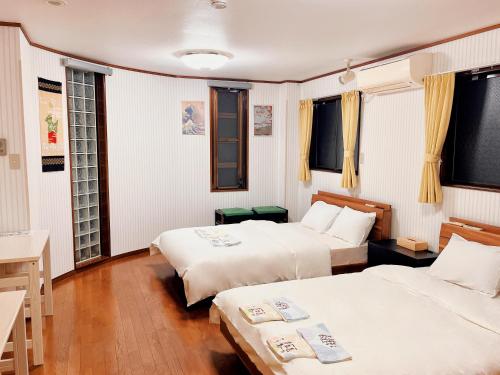 名古屋三木屋Mikiya 名古屋駅徒步600m 独栋别墅 3卧室5床2浴室2卫生间的客房设有两张床、一张书桌和窗户。