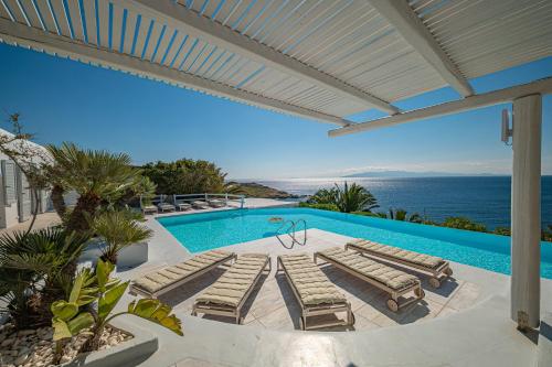 米克诺斯城Sanarte Villas Mykonos的一个带躺椅的游泳池,享有海景