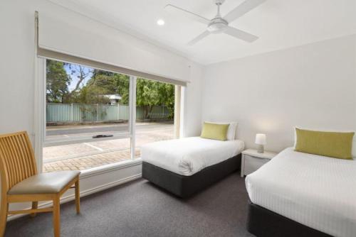 卡尔斯Island Breeze Resort的带大窗户的客房内的两张床