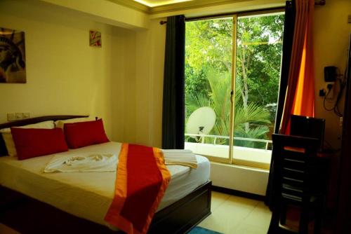 BandaragamaRiver Top Holiday Resort的一间卧室设有一张床和一个大窗户