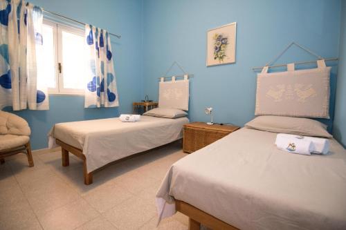 莱波拉诺A12-Masseria Villa Gandoli-Piscina的蓝色的客房设有两张床和窗户。