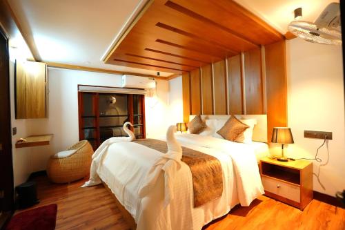 阿勒皮IndraprasthamLakeCruise的一间卧室配有一张大床,上面有天鹅