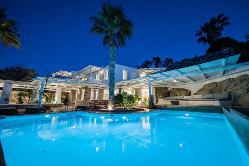 米克诺斯城Sanarte Villas Mykonos的棕榈树屋前的游泳池