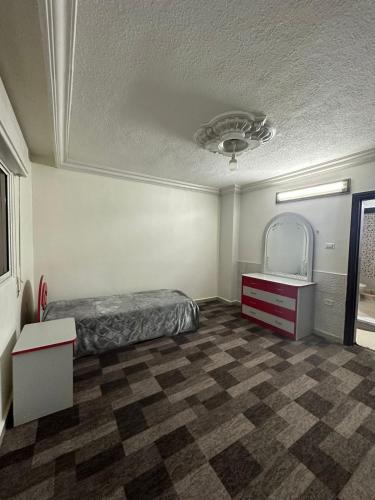 伊尔比德شقة مفروشة للايجار的配有床、梳妆台和镜子的房间