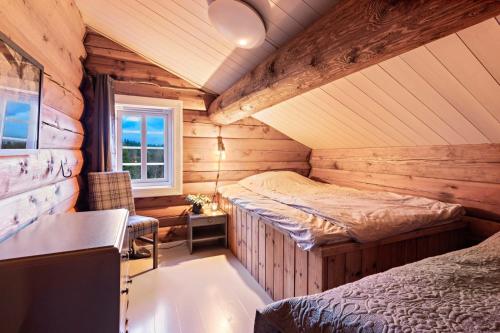 LislevatnLuxurious and modern log cabin close to nature的小木屋内一间卧室,配有两张床