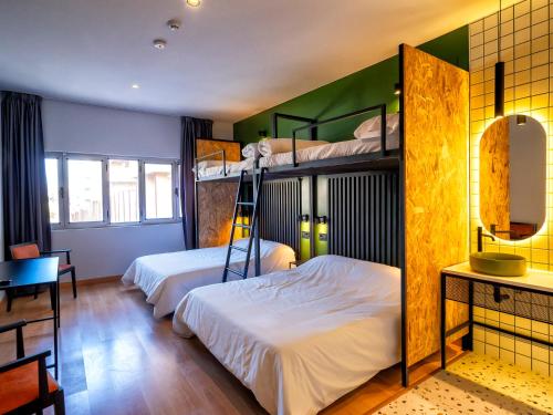 托莱多Wonder Hostel的一间卧室配有两张双层床和一张书桌