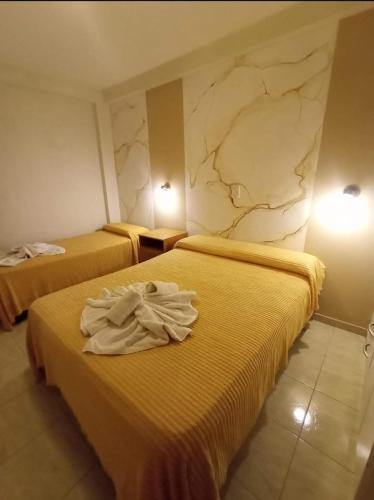 特尔马斯德里奥翁多HOTEL INTI YACU的两张位于酒店客房的床,配有毛巾