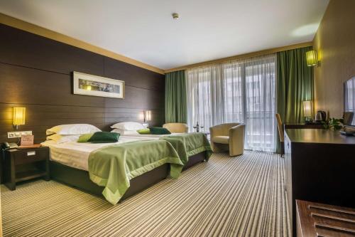 索非亚Best Western Plus Olives City Hotel - Free Parking的酒店客房带一张大床,带绿色窗帘