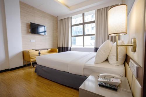 新山康帕斯酒店集团新山柑橘酒店的酒店客房配有一张床、一张书桌和一部电话