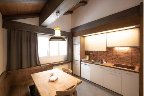拉格斯维拉巴德拉格斯公寓的厨房配有木桌和窗户。