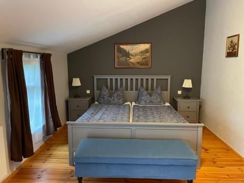 RippersrodaFerienhof"WaldEsel Rippersroda"的一间卧室配有一张大床和蓝色的搁脚凳