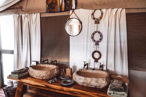 奥乔Ohorongo Tented Camp的浴室设有木桌上的两个盥洗盆