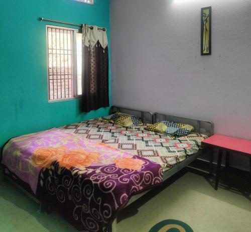 普里JHARANA GUEST HOUSE的一间卧室配有一张带五颜六色棉被的床