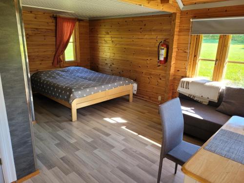 纳坦利Päiväkulma的小屋内一间卧室配有一张床和一张沙发