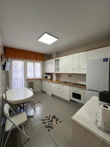 纳赫拉Apartamento en el Centro Histórico de Nájera的厨房配有白色橱柜、桌子和桌子