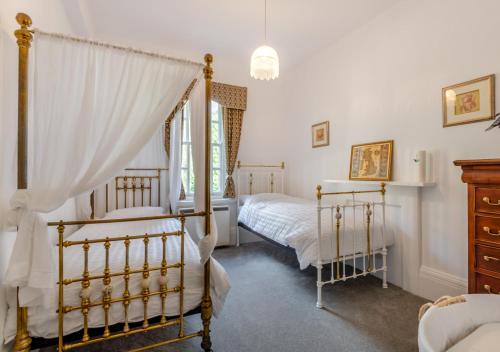 StradsettWaterhouse - Crimplesham Hall的一间卧室设有两张床和窗户。