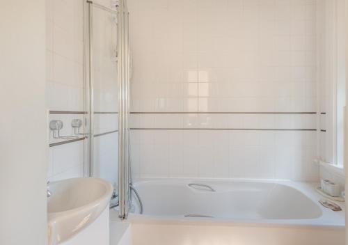 StradsettWaterhouse - Crimplesham Hall的白色的浴室设有浴缸和水槽。