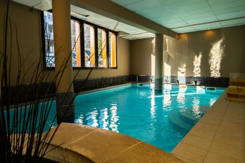 圣拉里苏朗Apparts au Cœur de St-Lary - Piscine Chauffée et Sauna的大楼内一个蓝色的大型游泳池