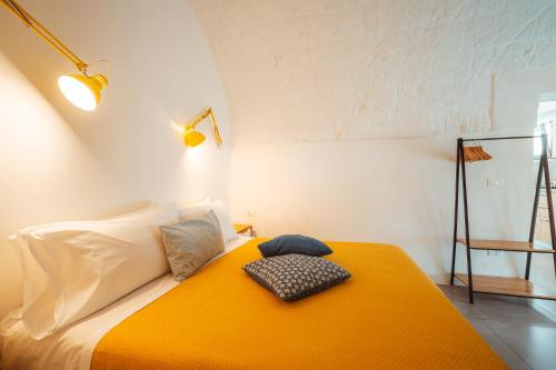 滨海波利尼亚诺Poseidonia-Housea Travel的一间卧室配有一张带橙色毯子的床