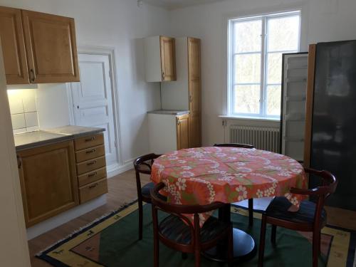 阿沃斯塔Lägenhet/Apartment Krylbo, Avesta Sweden的厨房配有桌子、椅子和冰箱。