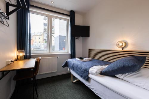 欧登塞Milling Hotel Mini 11的一间卧室配有一张床、一张书桌和一个窗户。