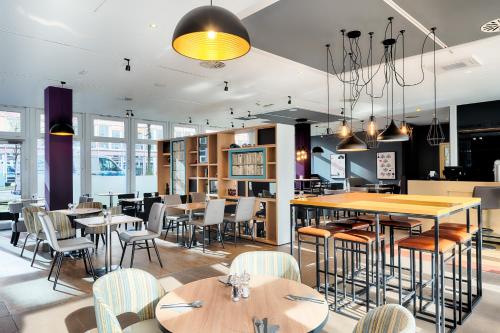 慕尼黑Premier Inn München City Ost的一间带桌椅的餐厅和一间酒吧