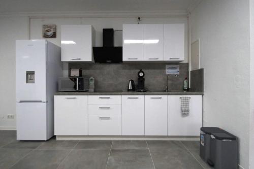 贝尔吉施格拉德巴赫Frühlings Apartments GL21的厨房配有白色橱柜和冰箱。