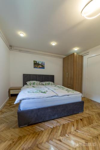 巴伊纳巴什塔BB Sima 1的一间卧室设有一张大床,铺有木地板