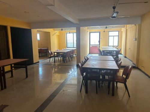 哥印拜陀Aishvarya Residency Coimbatore的用餐室设有桌椅和窗户。