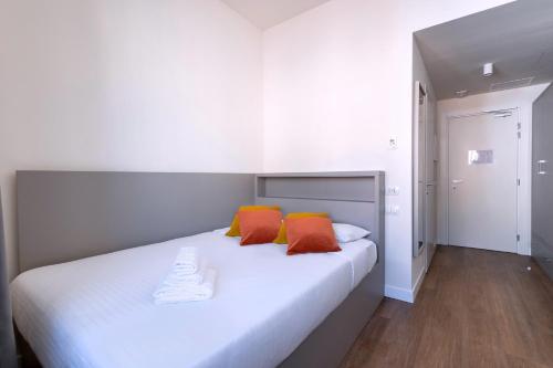 佛罗伦萨S4 Stays的卧室配有带橙色枕头的白色床