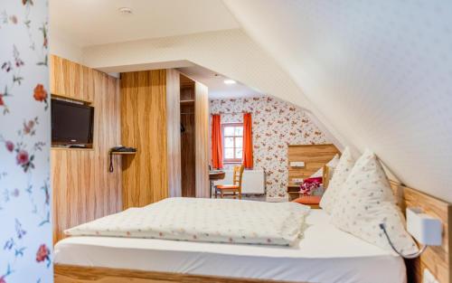 开姆尼茨福尔可乐热霍夫酒店的一间卧室配有一张床,并在一间客房内配有电视。