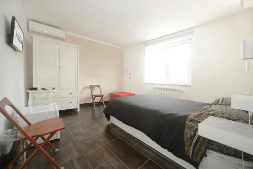 诺利La vita è bella - Noli的一间卧室配有一张床、一张书桌和一个窗户。