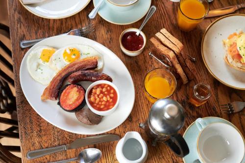 利克Black Lion Inn的一张桌子,上面有一盘早餐食品,包括鸡蛋和豆子