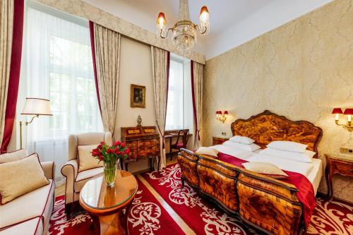 维也纳Hotel Stefanie - VIENNA'S OLDEST HOTEL的一间卧室配有一张大床和一张沙发