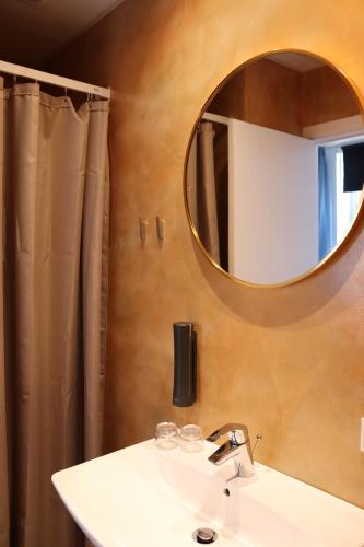 欧登塞Milling Hotel Ansgar的一间带水槽和镜子的浴室