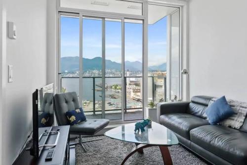 温哥华Bright and Modern Suite with Amazing views!的带沙发和大窗户的客厅