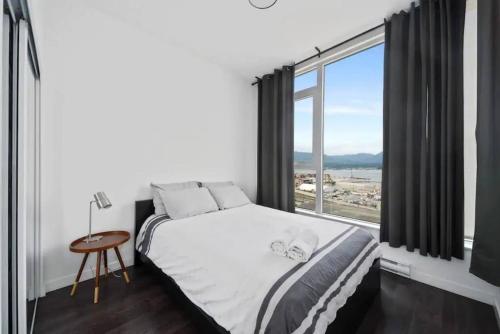 温哥华Bright and Modern Suite with Amazing views!的一间卧室设有一张床和一个大窗户