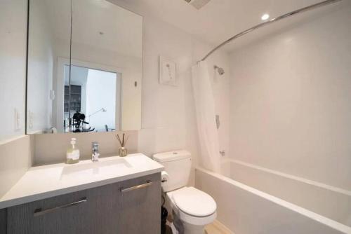 温哥华Bright and Modern Suite with Amazing views!的浴室配有卫生间、盥洗盆和浴缸。